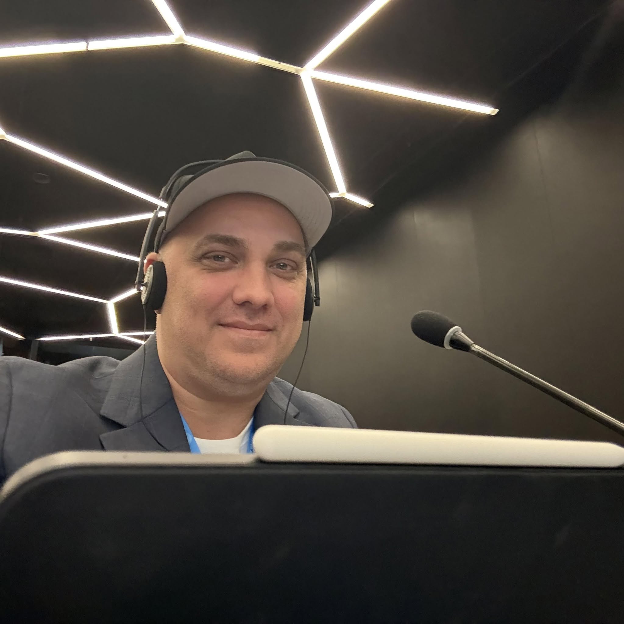 Brad D. Messner at a United Nations session, wearing an interpretation headset at a delegate microphone
